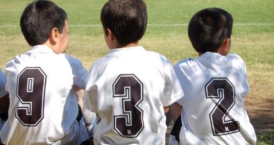 Bambini seduti sull'erba campo di calcio